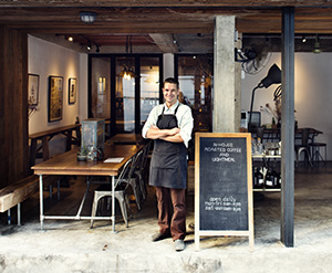 Business owner standing outside his local cafe where business is boosted with the help of web design Toms River professionals